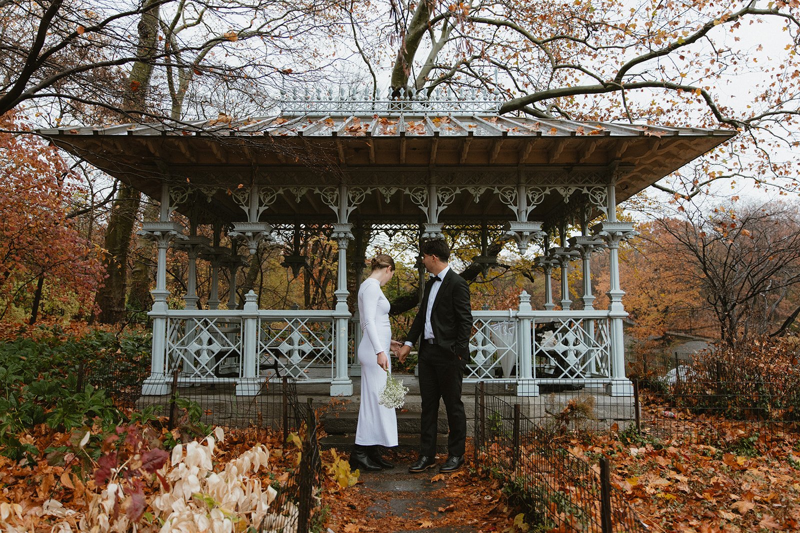 Newlyweds pose for portraits at the Ladies Pavilion during their NYC elopement, surrounded by the lake and greenery of Central Park.