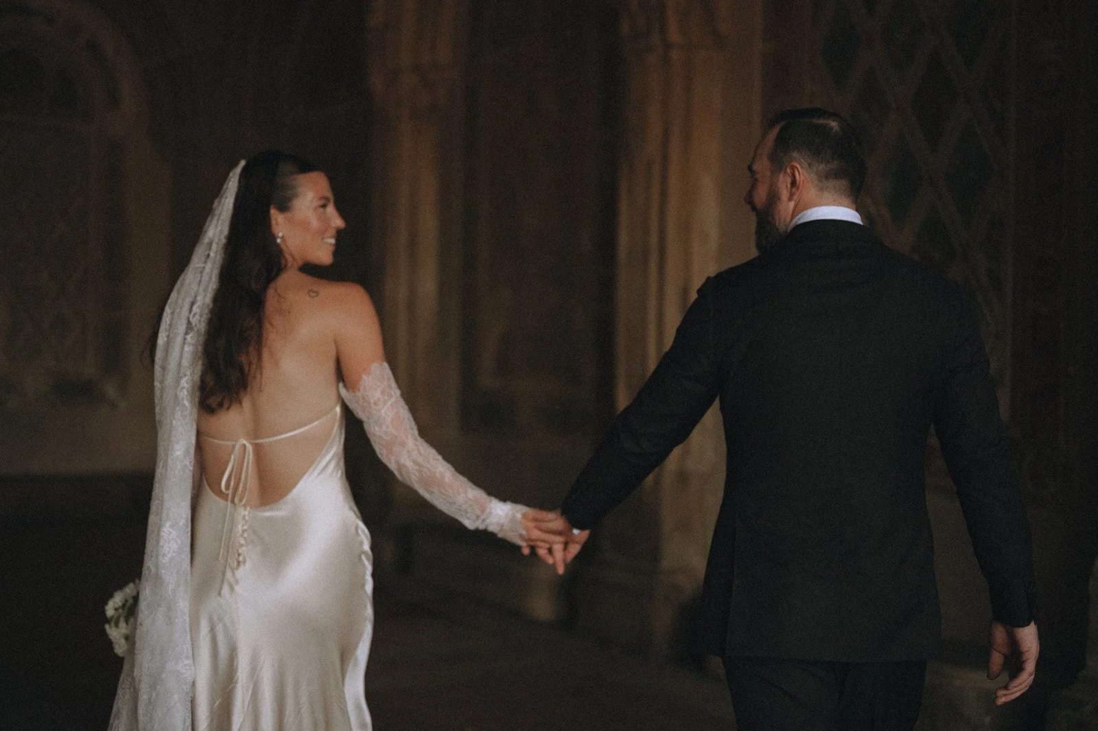 Bride and groom holding hands, walking under Bethesda Terrace in Central Park after their Cakewalk micro wedding.