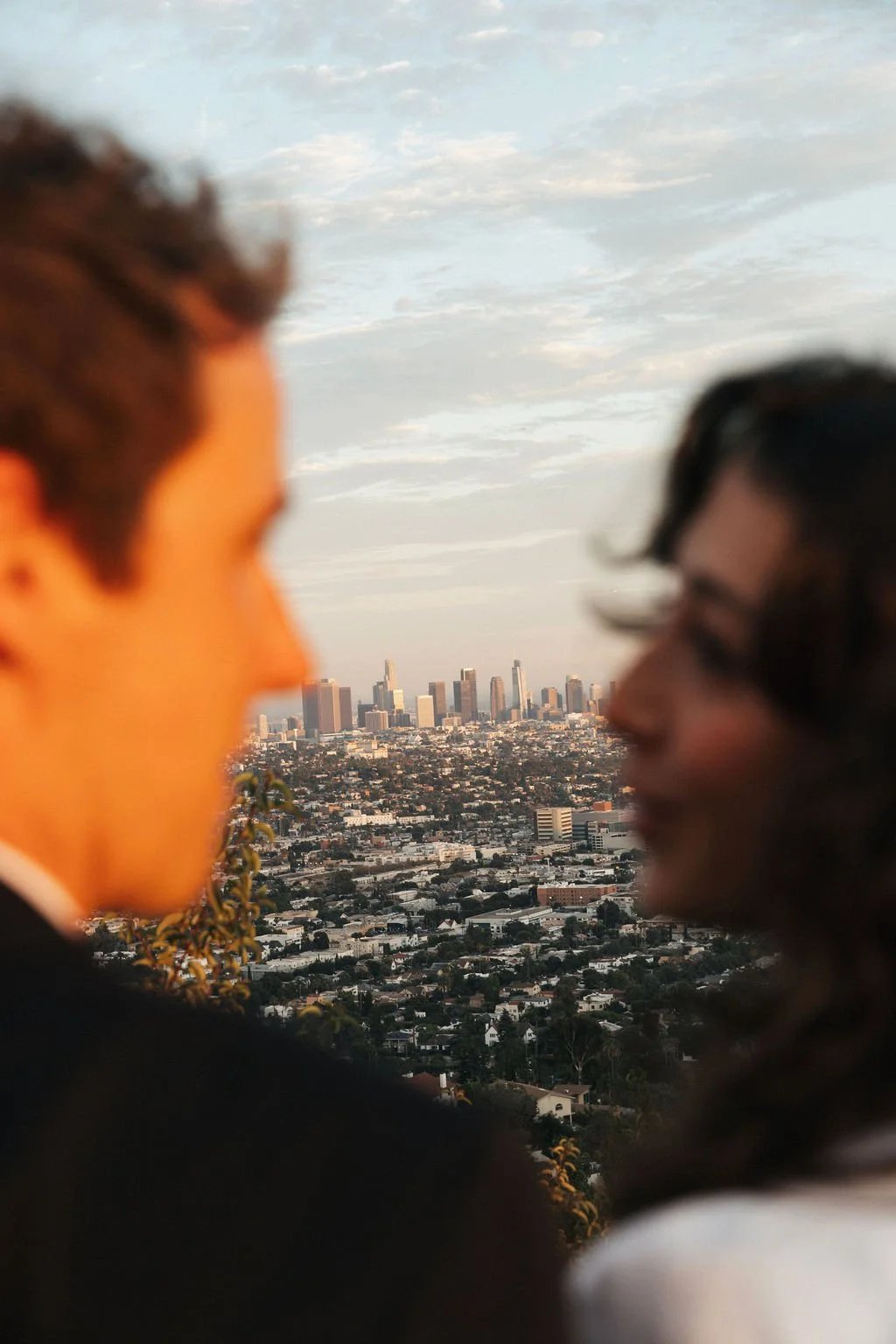 Couple close up with the Los Angeles downtown skyline in the background, overlooking the LA basin.
