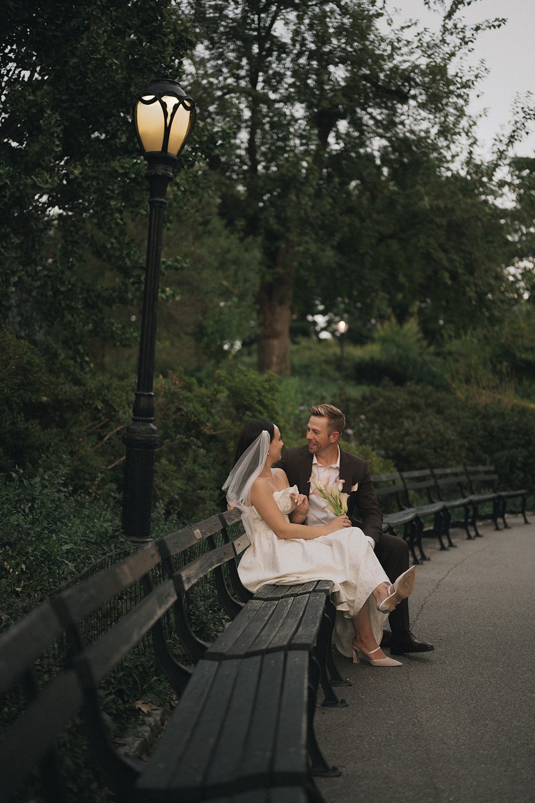 Bride and groom sitting on park bench in Central Park after their Cakewalk micro wedding.