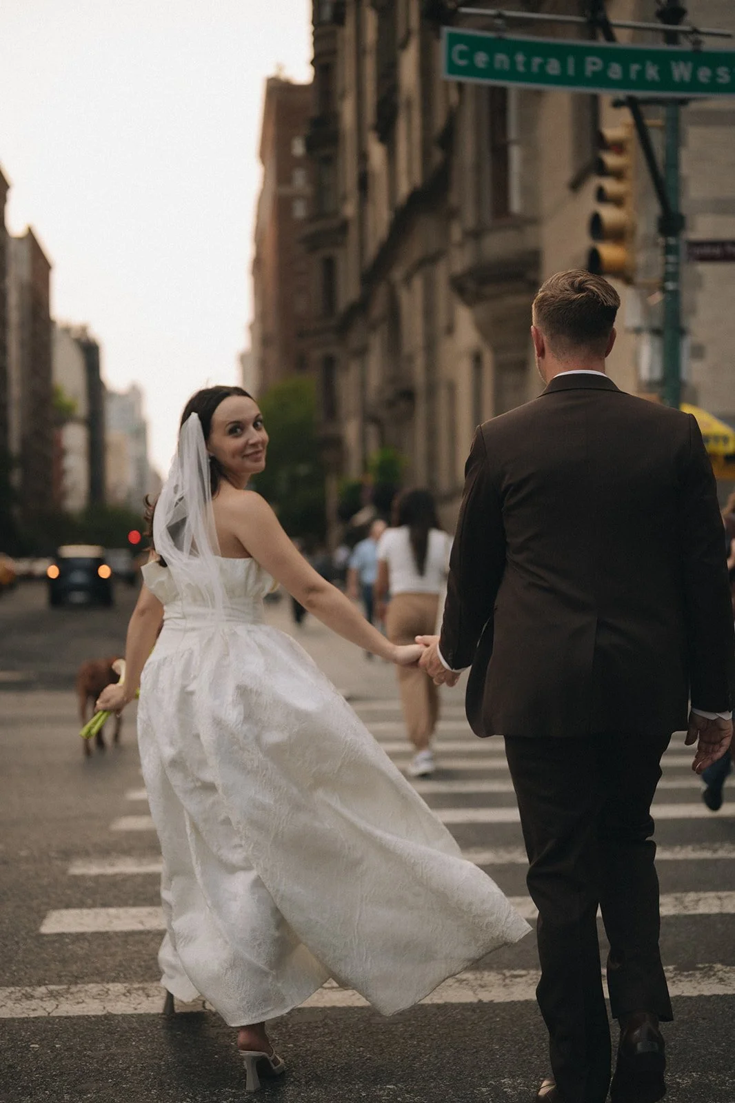 Bride and groom crossing the street leaving Central Park after their Cakewalk elopement ceremony.