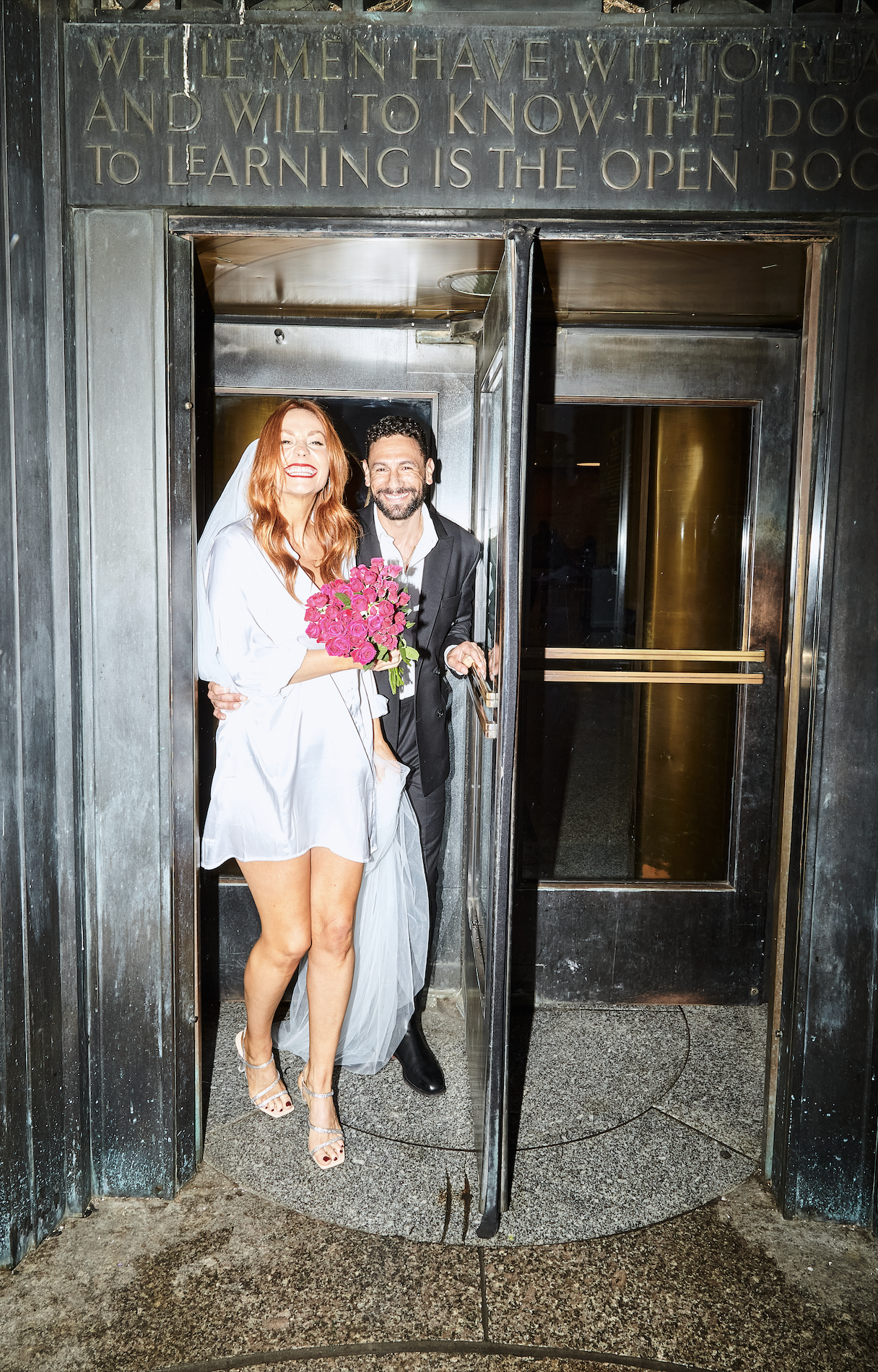 Bride and groom emerging from the revolving door at Brooklyn Central Library.