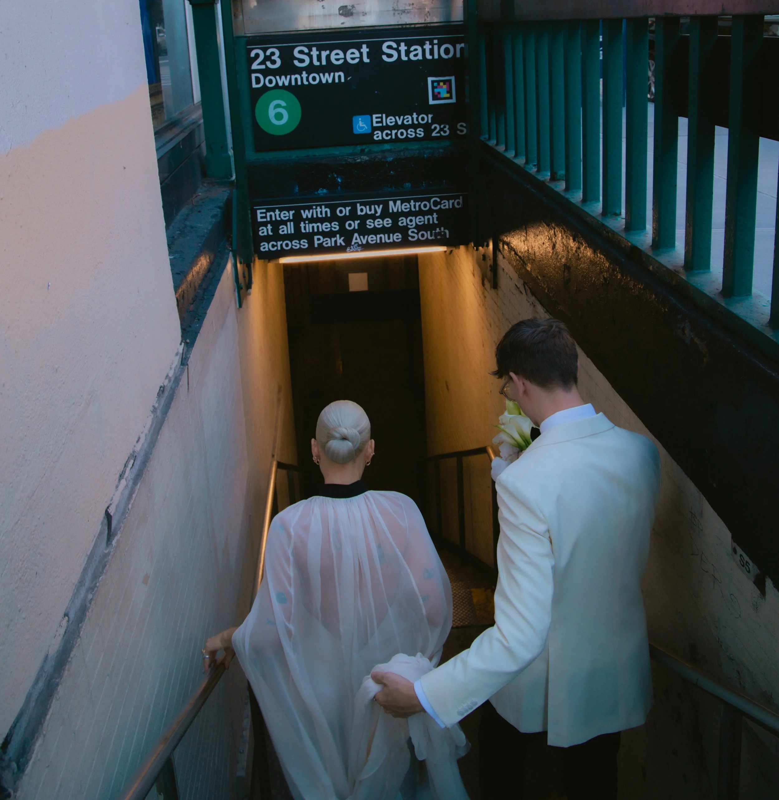 Bride and groom descending the stairs into 23rd Street Station in Manhattan after their Cakewalk elopement ceremony.
