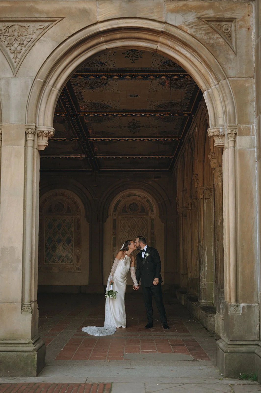 Bride and groom kissing under the arches at Bethesda Terrace in Central Park after their Cakewalk micro wedding.