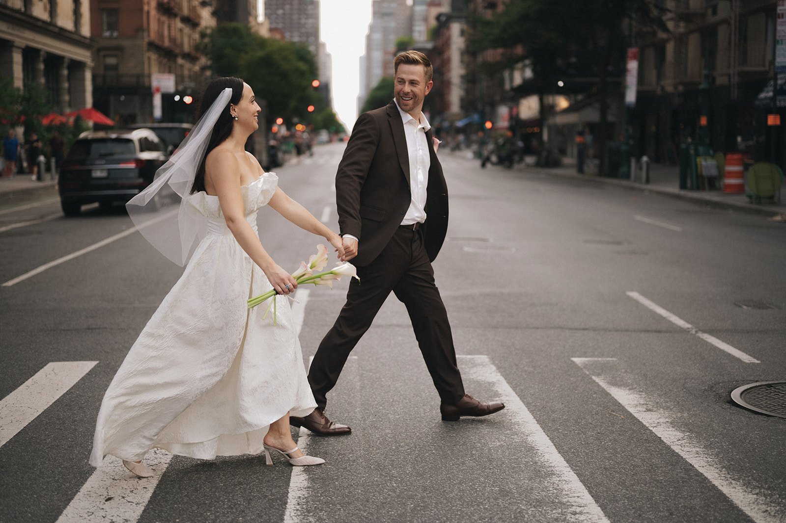 Bride and groom crossing the street in Manhattan after their Cakewalk elopement ceremony.