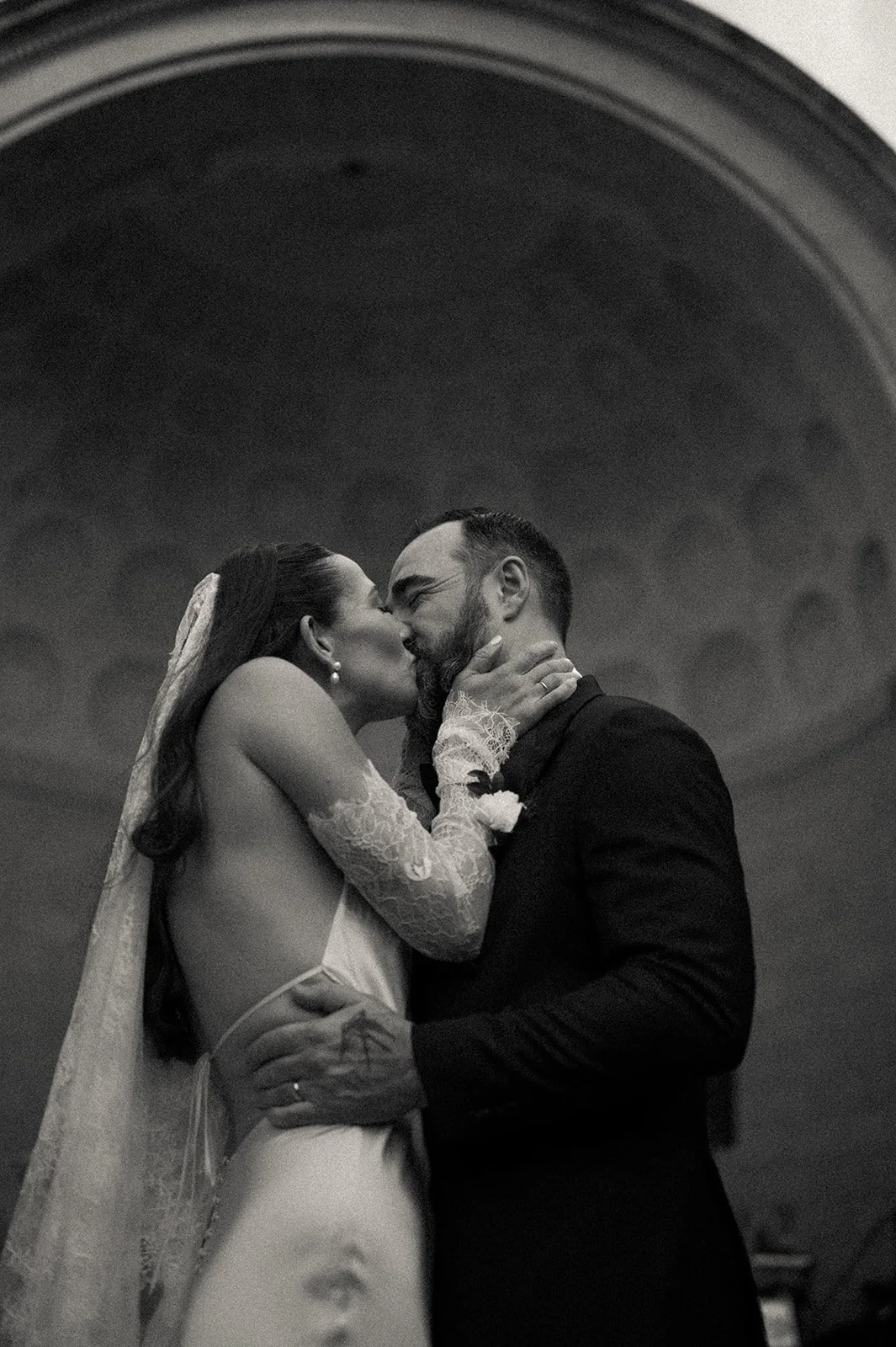 Bride and groom kiss with Naumburg Bandshell behind them at their Central Park micro wedding by Cakewalk.