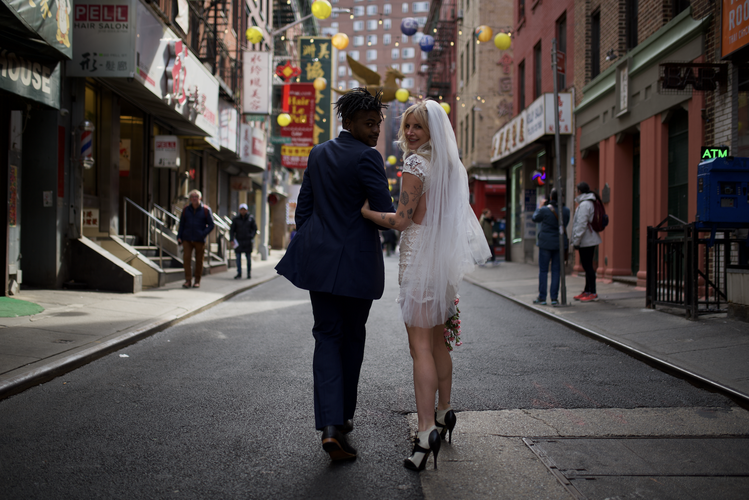 Bride and groom walking down the street in Chinatown after their Cakewalk elopement.