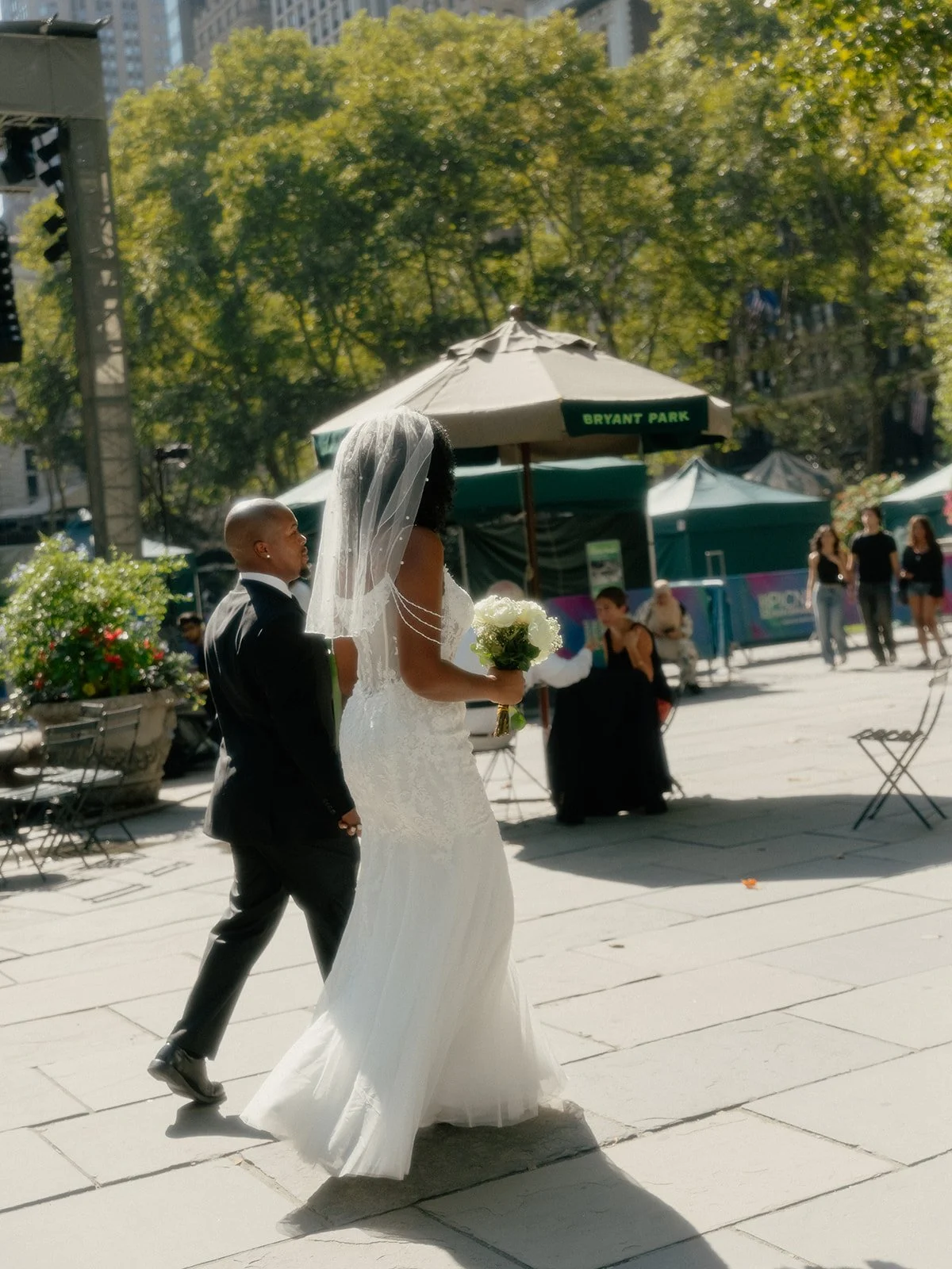 Bride and groom walking away in Bryant park after their Cakewalk elopement ceremony.