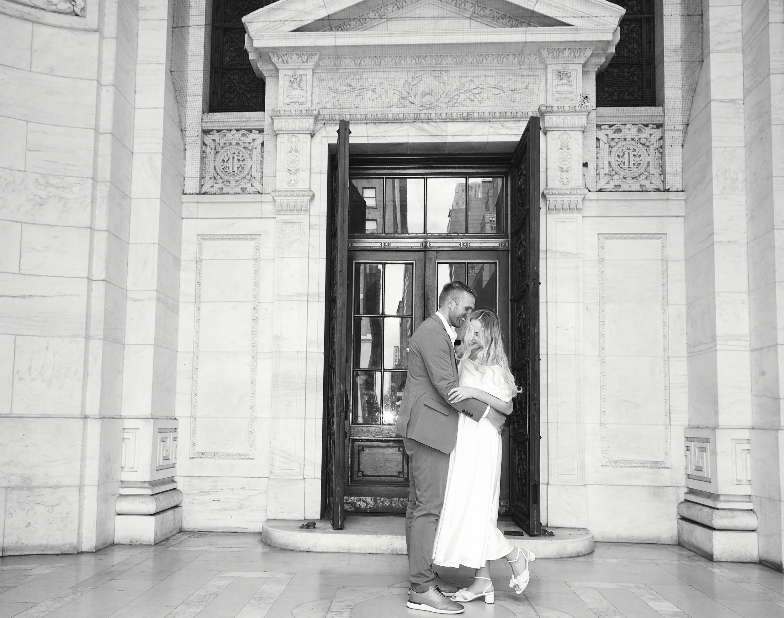 Bride and groom kissing in front of a doorway at Bryant Park after their Cakewalk elopement.