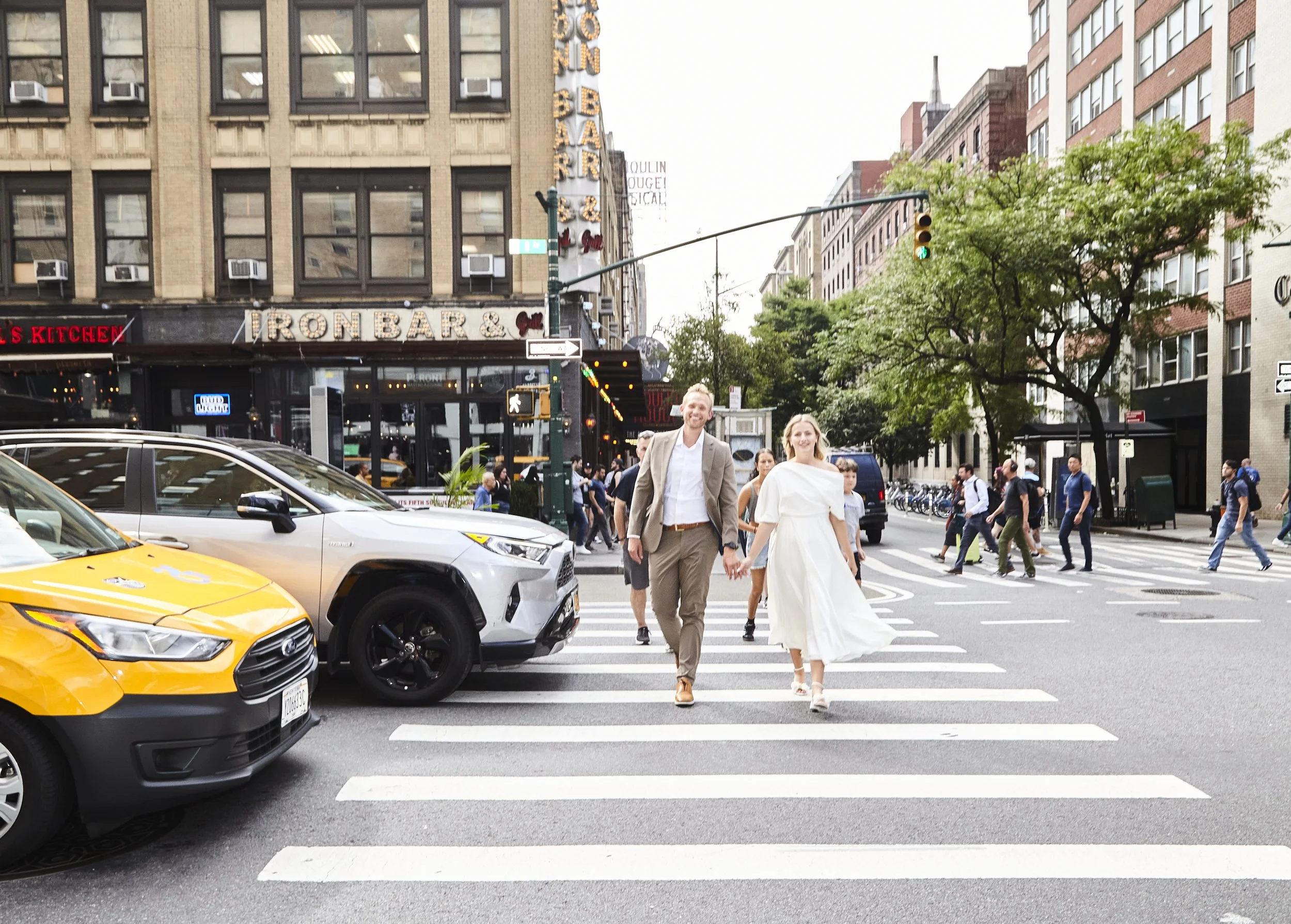 Bride and groom crossing the street in Manhattan, headed to their Cakewalk elopement.