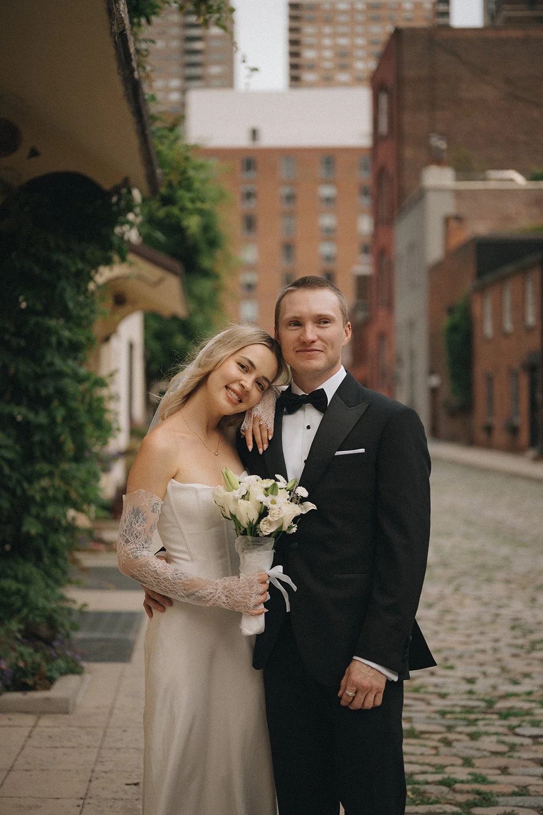 Couple posing on the cobblestone street in the West Village after their Cakewalk elopement.