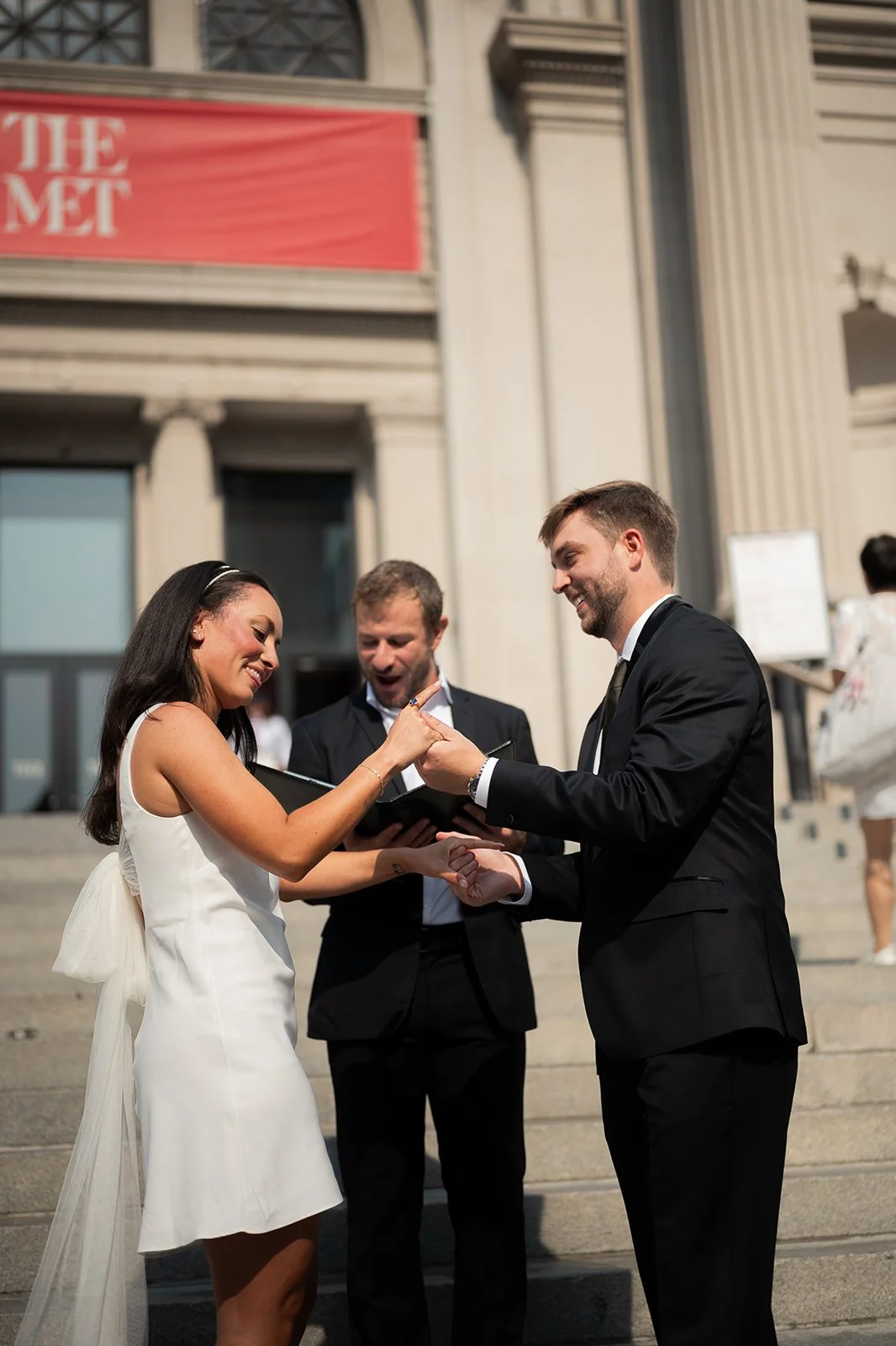 Kayla and Zach exchanging rings during their intimate wedding ceremony on the steps of the Metropolitan Museum of Art.