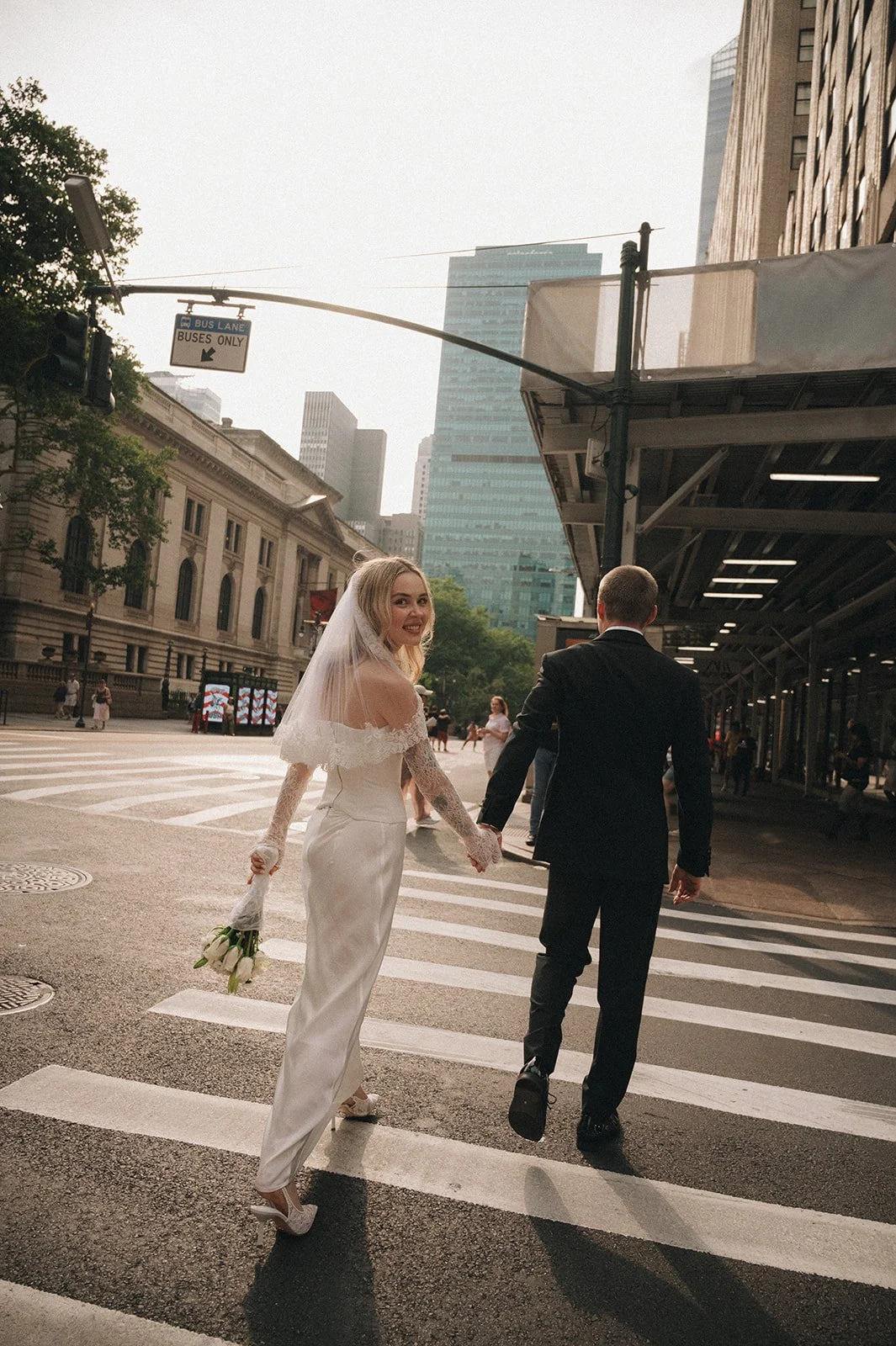 Couple crossing a quiet street in a wedding gown and tuxedo during their Cakewalk elopement.