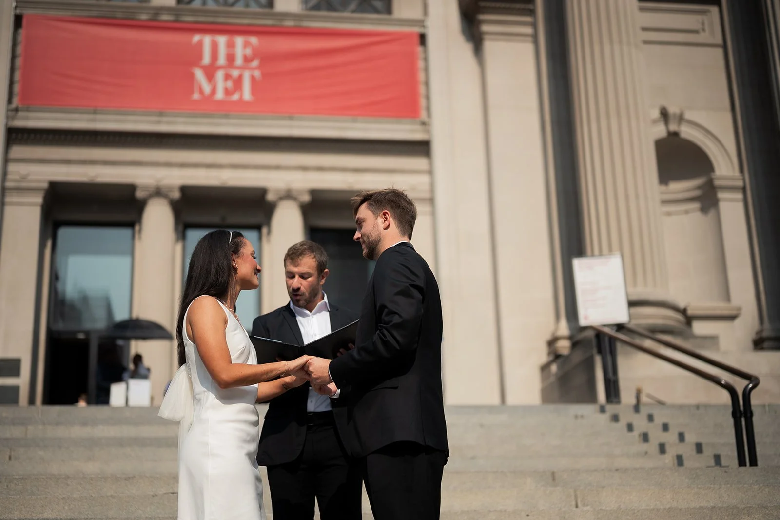 Bride and groom getting married by their officiant on the Met Steps.