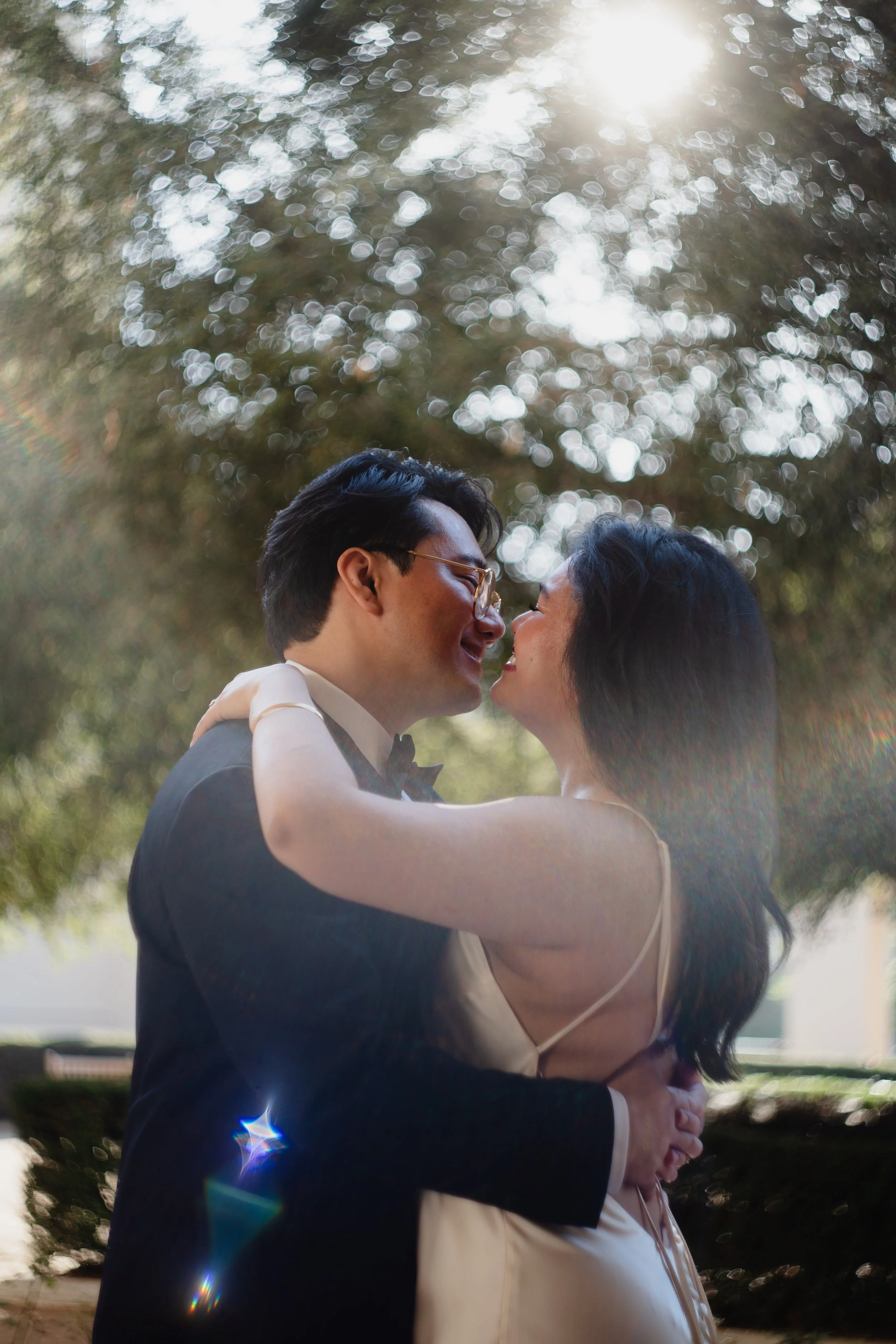 Bride and groom kissing under a tree in Old Pasadena after their Cakewalk elopement.