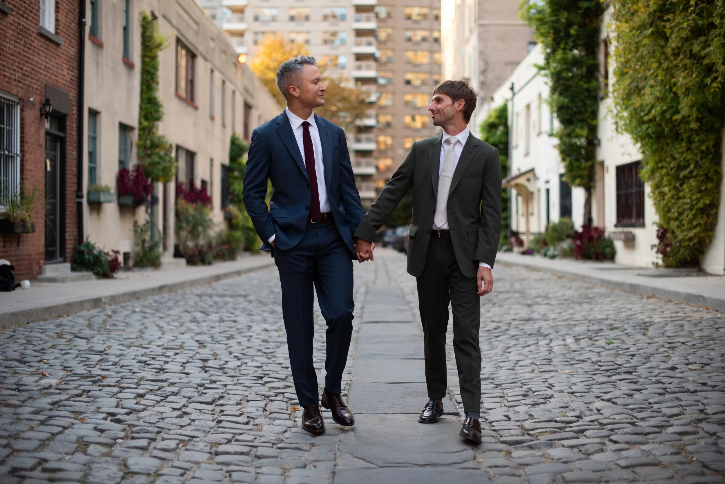 Two men walking a cobblestone path in the West Village the way to their Cakewalk elopement ceremony.