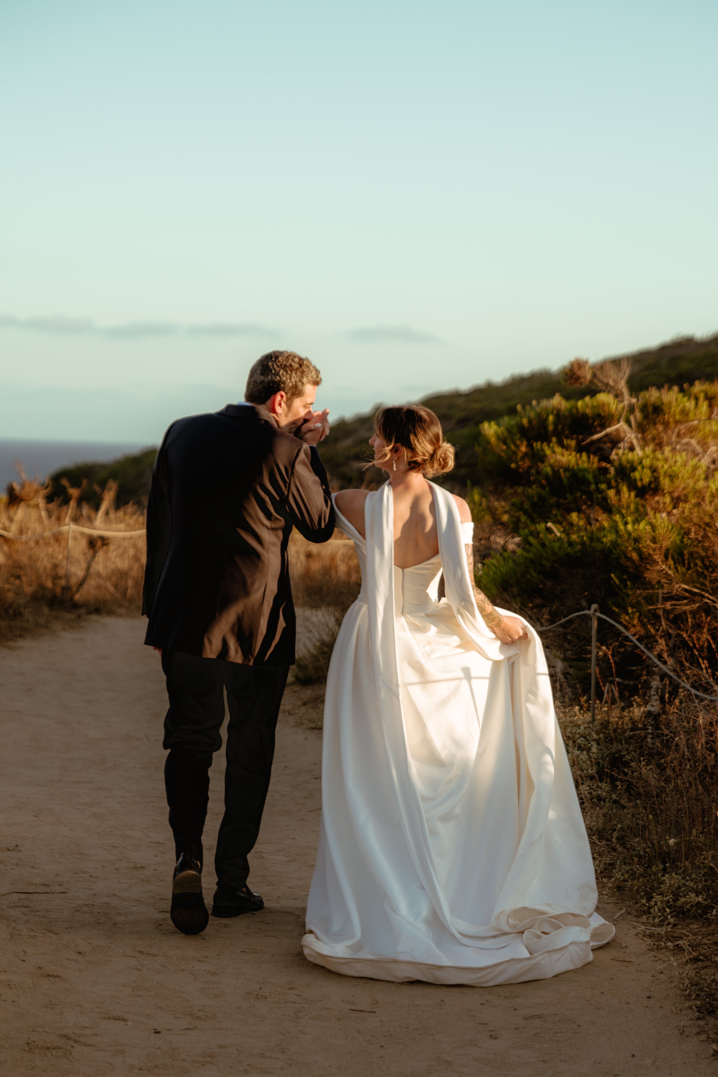 Bride and groom walking the Point Dume pathways after their Cakewalk micro wedding.