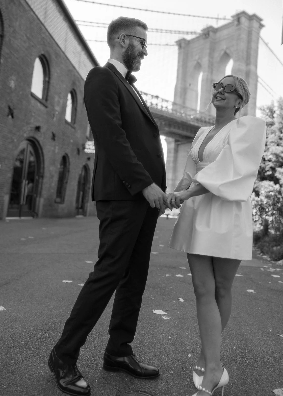 Bride and groom dancing in front of the Brooklyn Bridge after their Cakewalk elopement.