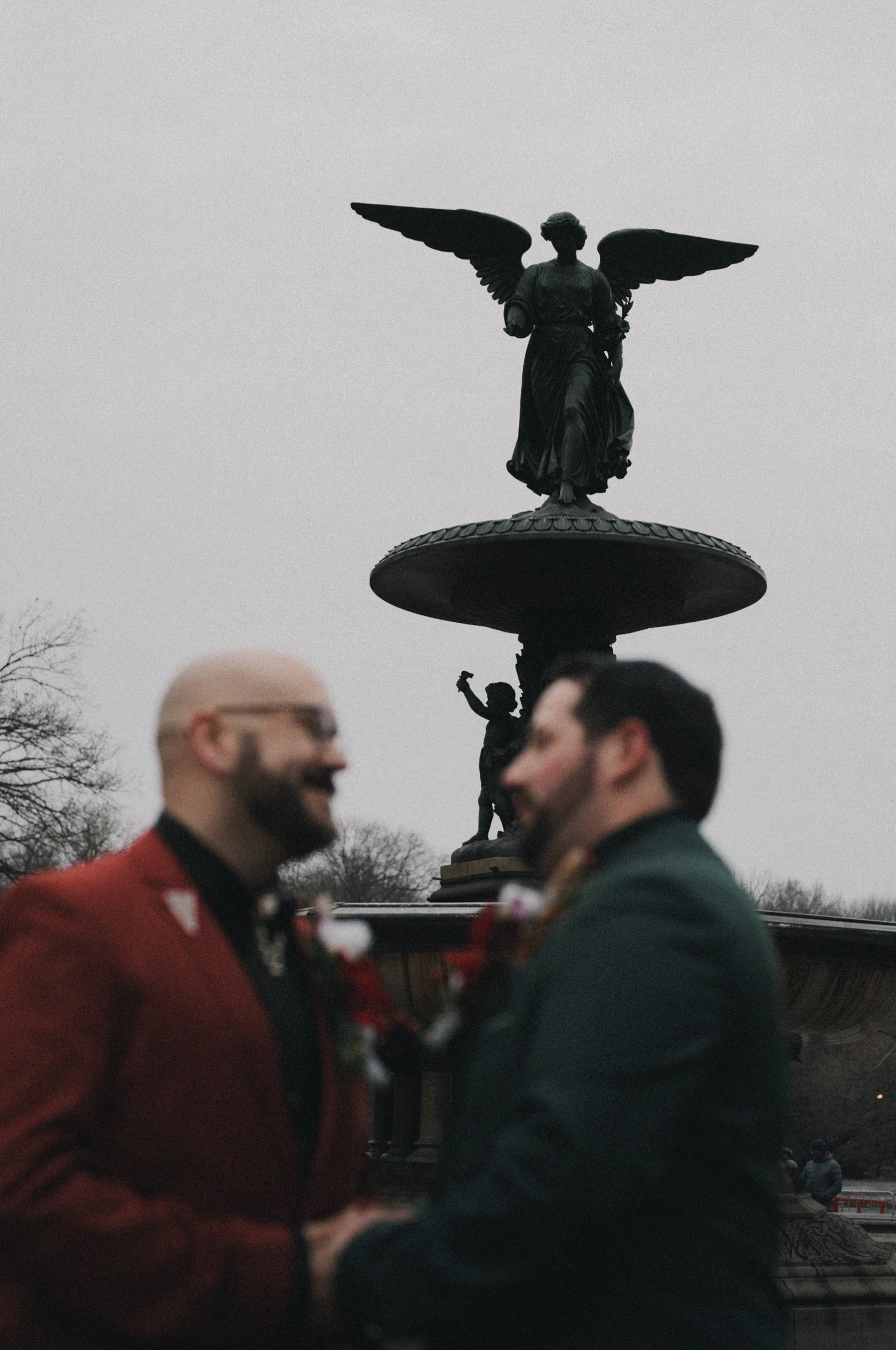 Documentary style image of LGBT couple at Bethesda Terrace Fountain before their elopement ceremony officiated by Cakewalk.