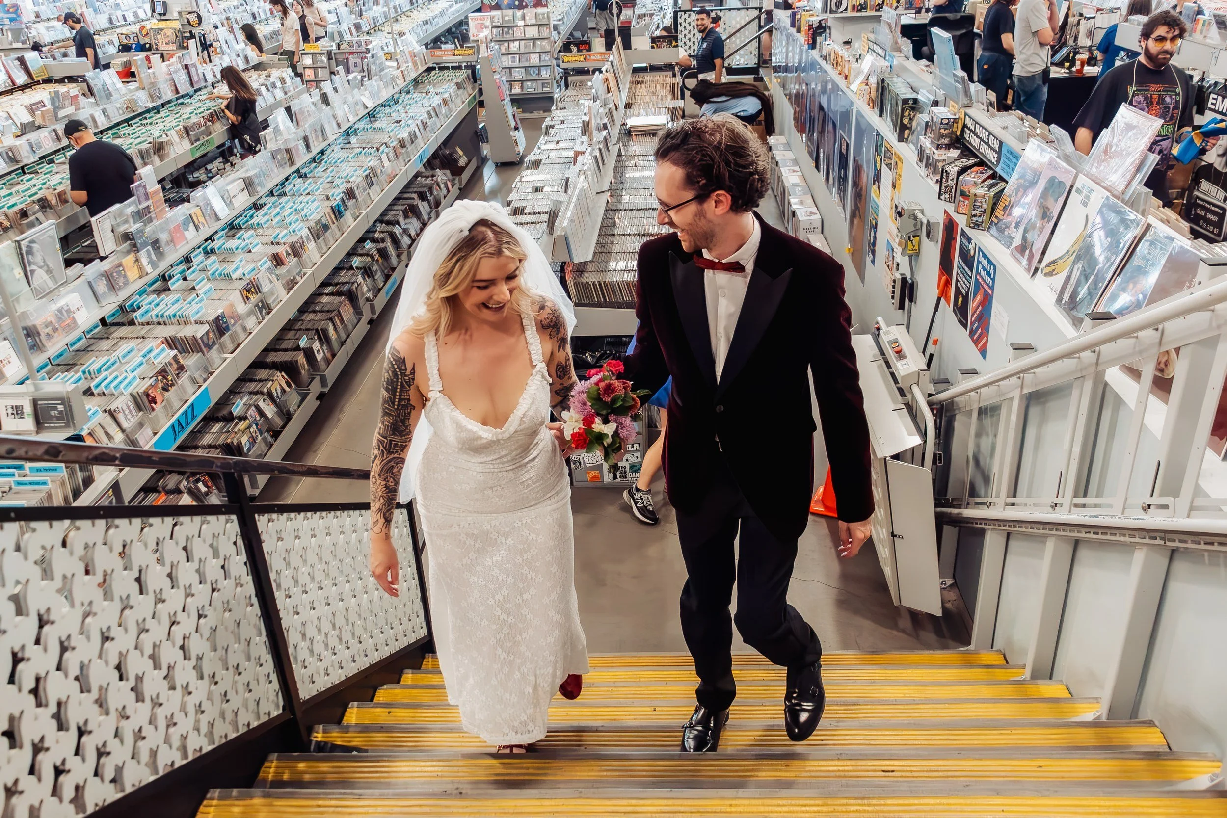 Emma and Adam on the stairs inside Amoeba Music during their Hollywood elopement.
