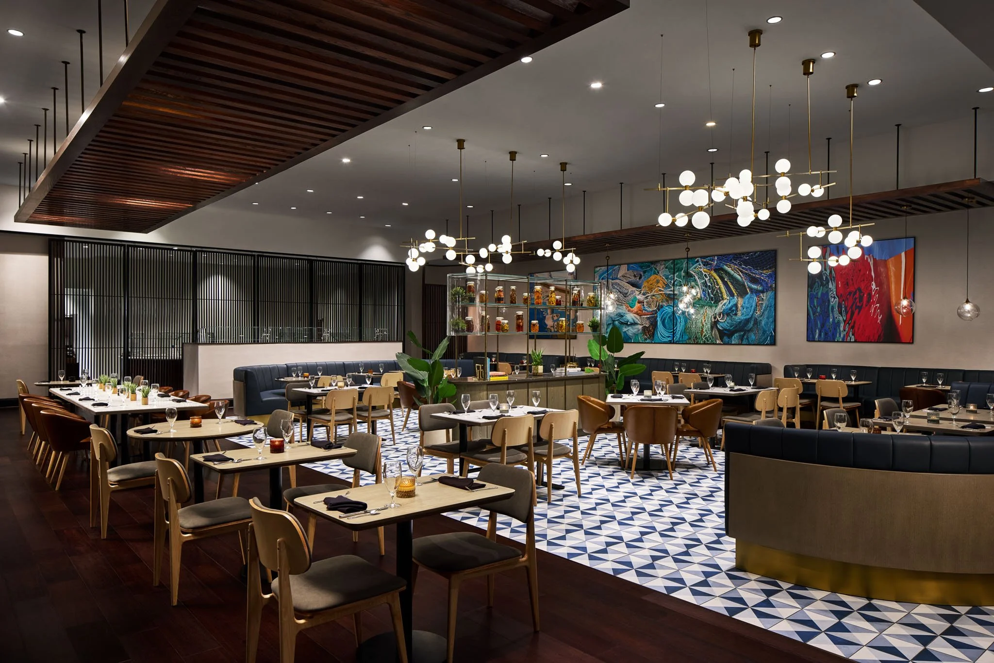 Elegant restaurant interior with modern lighting, artwork, and tables set for dining.