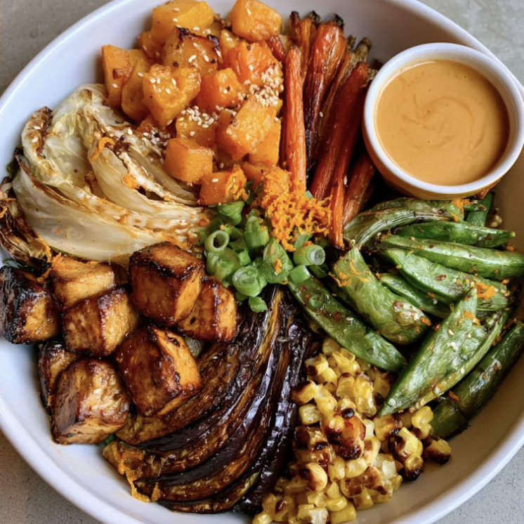 Sesame Glow Bowl with Salt & Pepper Tofu, Butternut Squash, Napa Cabbage, Carrots, Japanese Eggplant, Snap Peas, Corn, Scallions, Sesame Seeds, Orange Zest, Orange Sesame Sauce