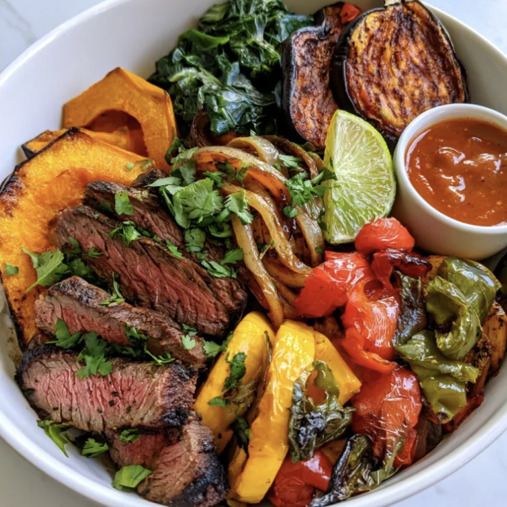 Charred Iron Bowl with Smoky Fajita Steak, Butternut Squash, Caramelized Onion, Collard Green, Squash, Red Pepper, Green Pepper, Paprika Eggplant, Cilantro, Lime, Smoky Sherry Pepper Sauce