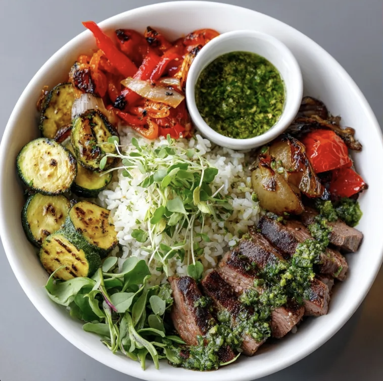 Chimichurri Power Bowl with Argentinian Steak, Tomato Garlic White Rice, Zucchini, Red Peppers, Caramelized Onion, Spinach, Scallions, Microgreens, Chimichurri Sauce