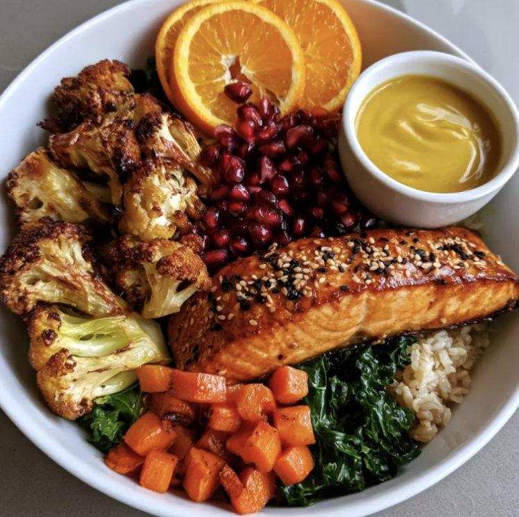Golden Omega Bowl with Orange Sesame Salmon, Brown Rice, Cauliflower, Carrots, Kale, Pomegranate, Toasted Sesame Seeds, Citrus Turmeric Tahini Sauce