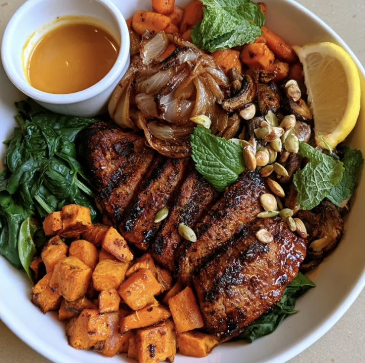 Harissa Strength Bowl with Moroccan Harissa Steak, Sweet Potato, Carrots, Caramelized Onions, Mushrooms, Spinach, Mint, Pepitas, Lemon, Apricot Mustard Jus