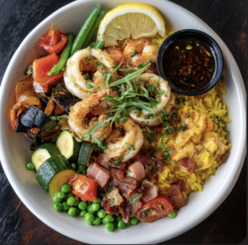 For Pros: Paella Seafood Bowl with Poached Calamari, Mussels, and Shrimp with Saffron Rice, Zucchini, Cherry Tomatoes, Green Beans, Red Peppers, Diced Ham, Green Peas, Lemon, Sofrito Sauce