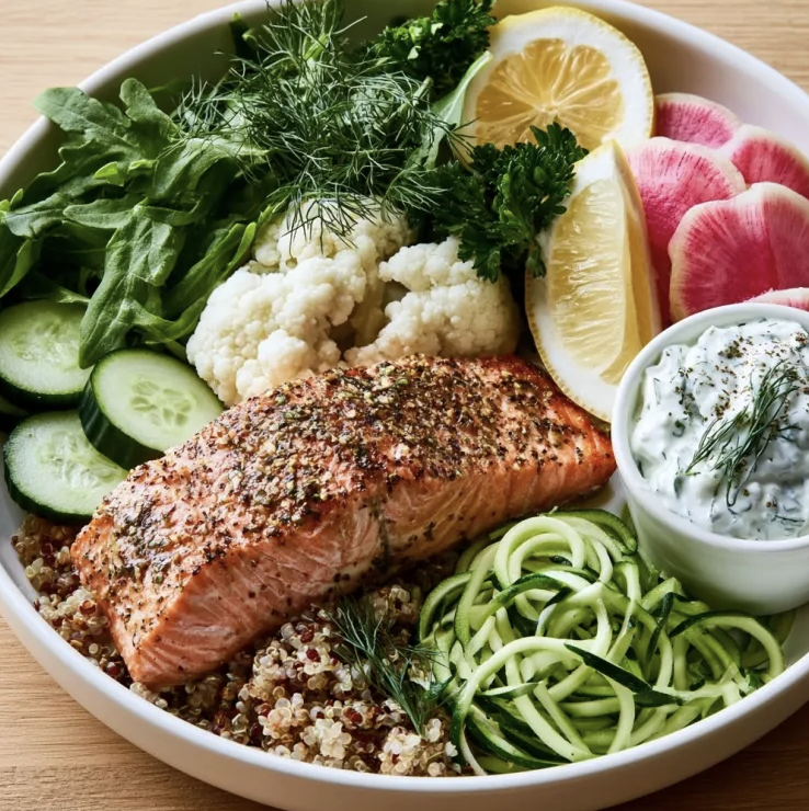 Santorini Refresh Bowl with Greek Lemon Olive Salmon, Quinoa, Cauliflower, Cucumber, Zucchini Noodles, Arugula, Watermelon Radish, Dill, Parsley, Lemon, Tzatziki Sauce