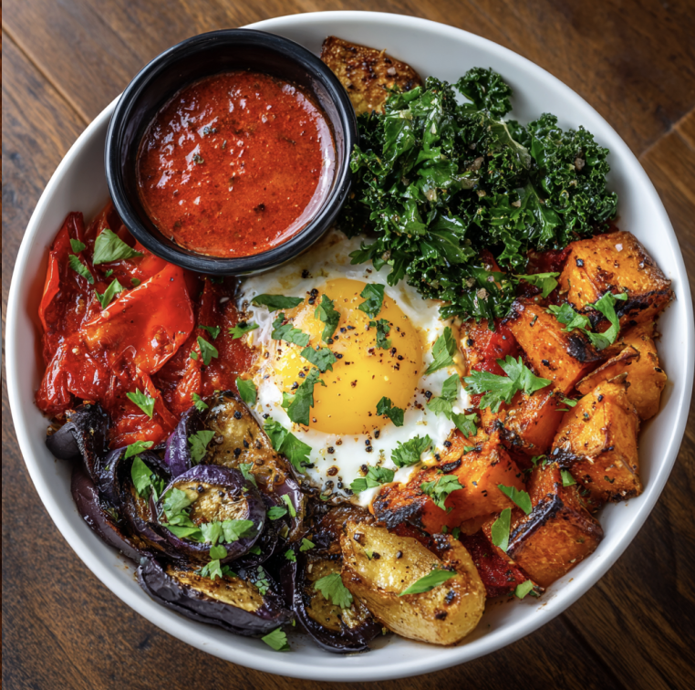 Red Shakshuka Bowl with Shakshuka Eggs, Roasted Red Peppers, Roasted Eggplant, Steamed Kale, Sweet Potato, Parsley, Red Shakshuka Sauce