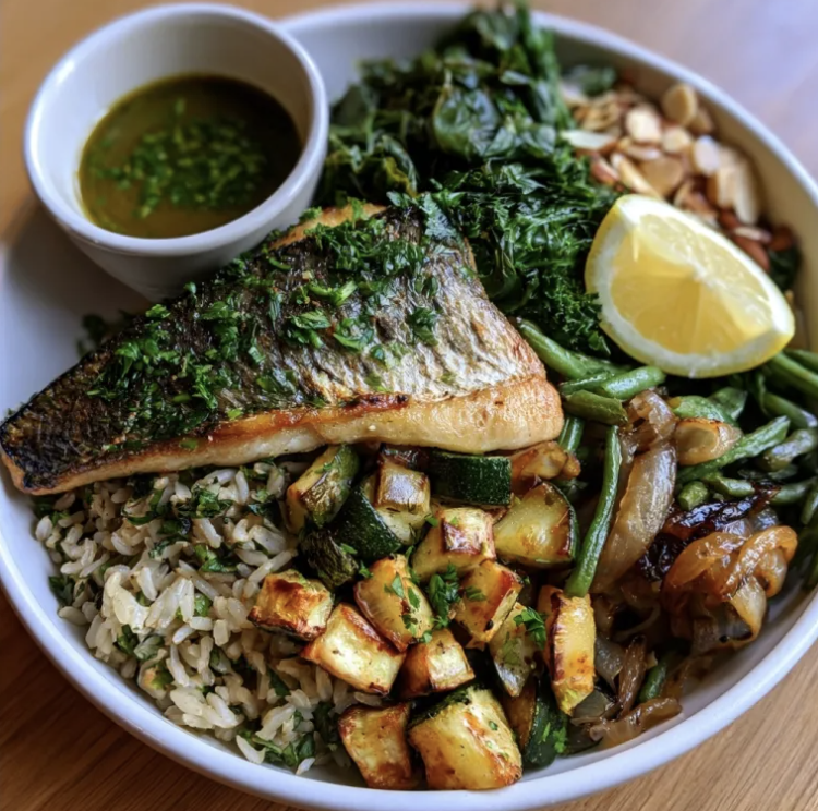 Mediterranean Nourish Bowl with Seared Herb Branzino, Tomato Basil Basmati, Zucchini, Caramelized Onions, String Beans, Kale, Almonds, Lemon, Parsley, Tarragon Chive Vinaigrette