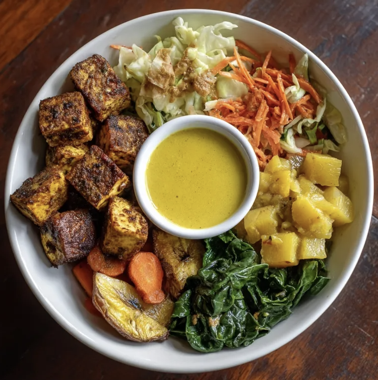 Caribbean Jerk Bowl with Jerk Tofu, Roasted Plantains, Cabbage, Collard Greens, Cumin Roasted Carrots, Coconut Flakes, Pineapple, Pineapple Coconut Curry Sauce