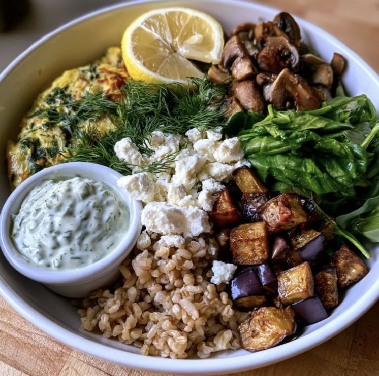 Garden Frittata Bowl with Summer Kale & Tomato Frittata, Brown Rice, Roasted Eggplant, Fresh Spinach, Sautéed Mushrooms, Dill, Lemon, Feta, Creamy Dill Garlic Sauce