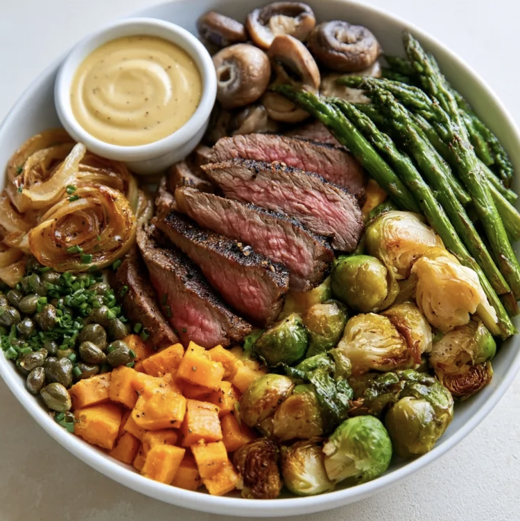 Iron Strength Bowl with Steak au Poivre, Roasted Sweet Potato, Brussels Sprouts, Caramelized Onions, Asparagus, Mushrooms, Chives, Capers, Creamy Dijon Sauce