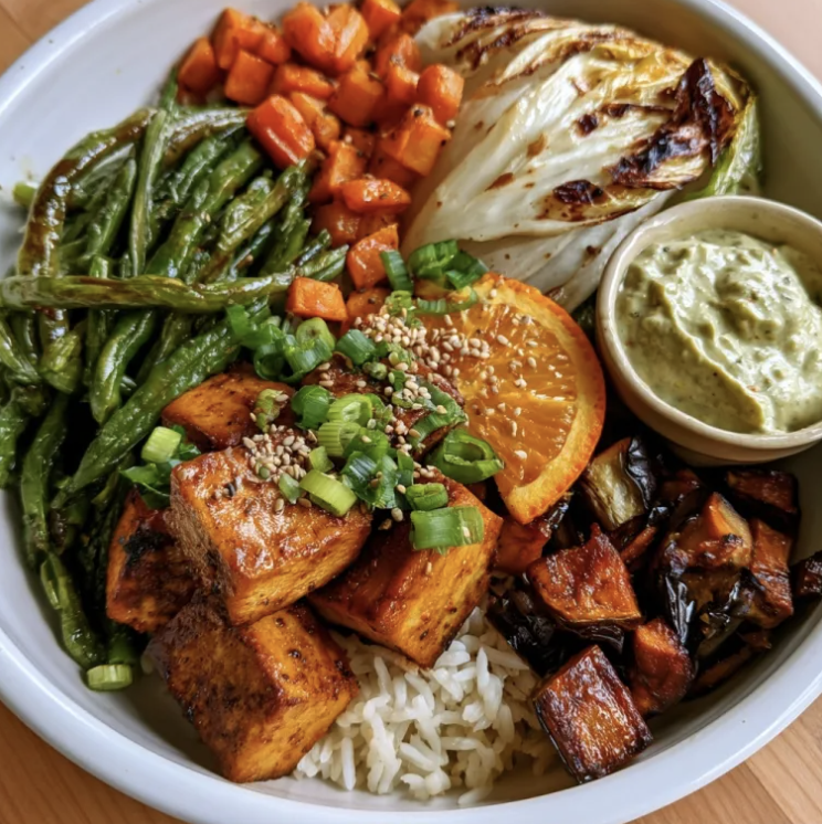 Smoky Verde Bowl with Smoky Poblano Tofu, Basmati Rice, Carrots, Napa Cabbage, Swiss Chard, Scallions, Sesame Seeds, Orange Slice, Creamy Poblano Pepita Sauce