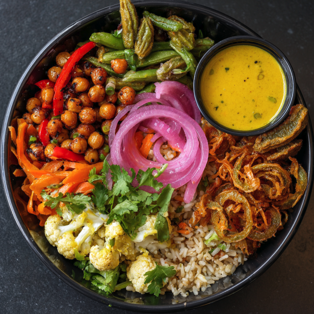 Anti Inflammatory Bowl with Chickpeas, Brown Rice, Red Pepper, Snap Peas, Cauliflower, Carrots, a Coconut–Turmeric Curry Dressing, Pickled Red Onion, Crispy Okra, and Cilantro