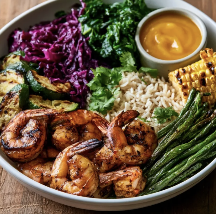 Tropical Protein Bowl with Caribbean Jerk Shrimp, Basmati Rice, Braised Red Cabbage, Zucchini, Green Beans, Kale, Grilled Corn, Fresh Cilantro, Jerk Mango Sauce