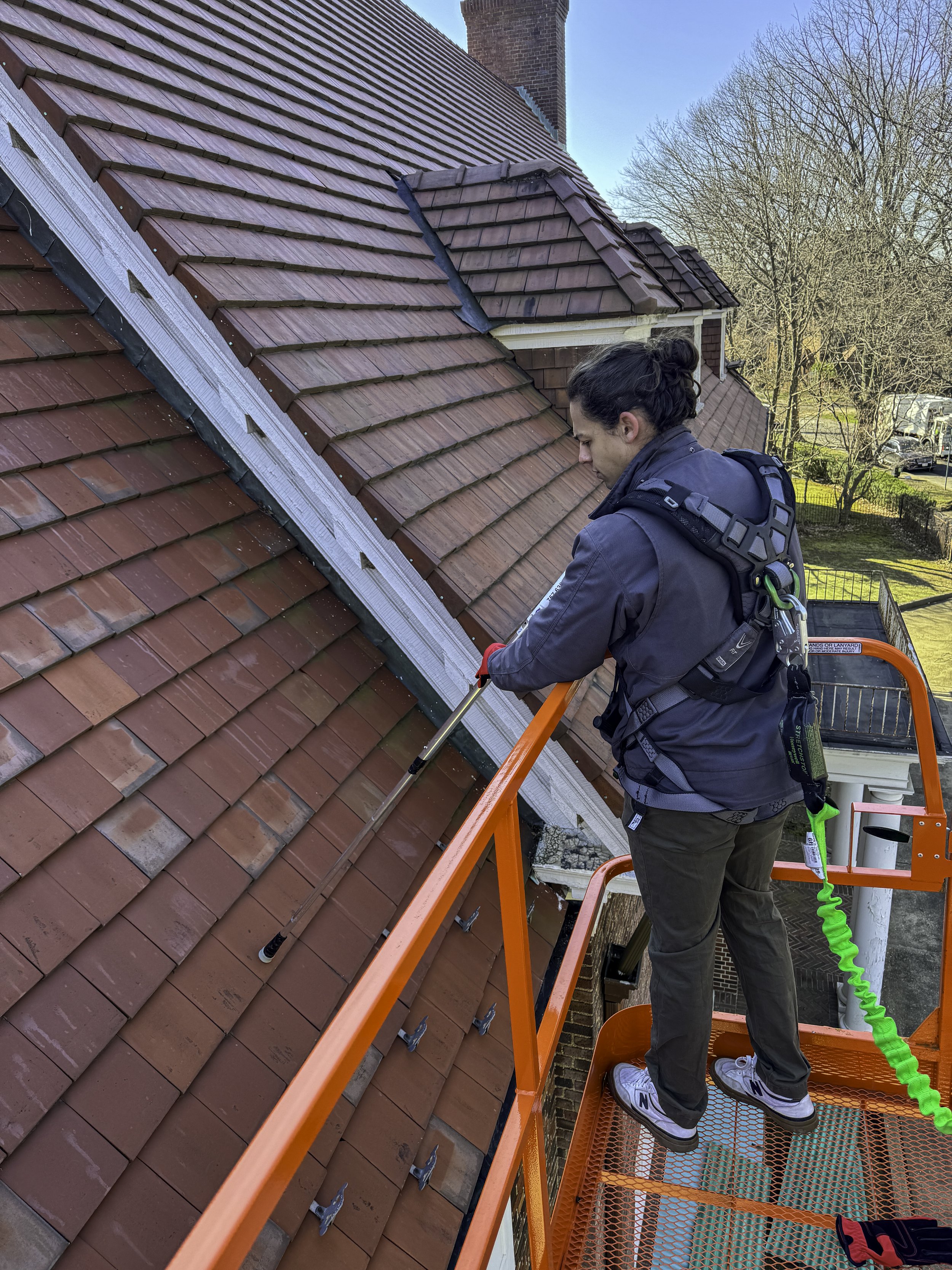 Photo of an Engineer up on a lift performing a leak investigation on a client's roof