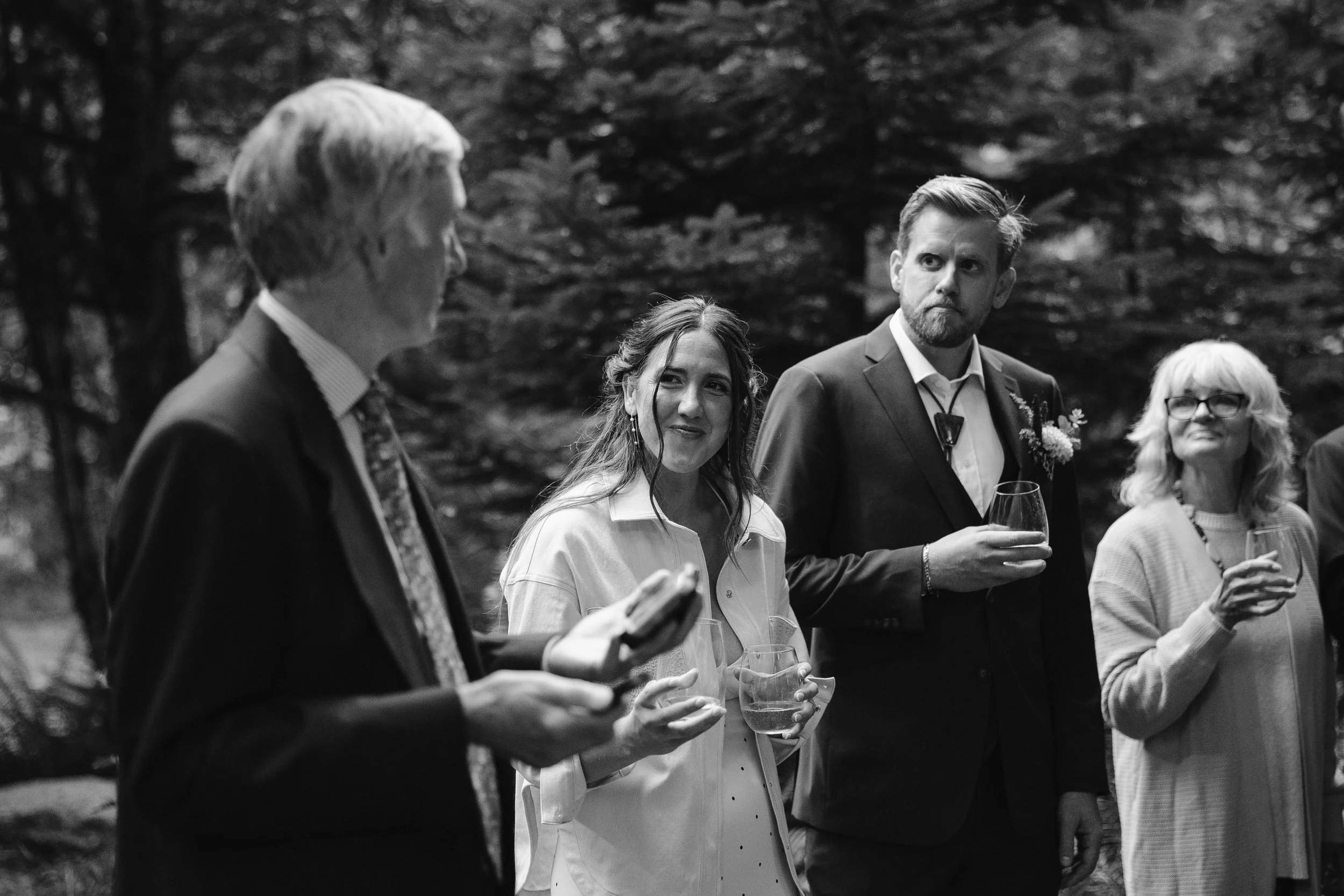 Bride listening to a toast during an intimate elopement reception with family