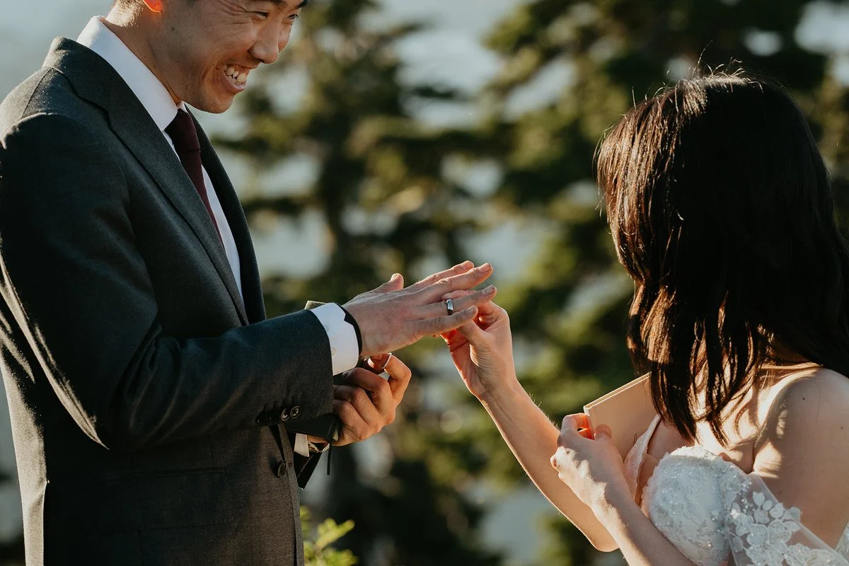 Bride placing a wedding ring on groom's finger during an intimate outdoor elopement ceremony.jpg