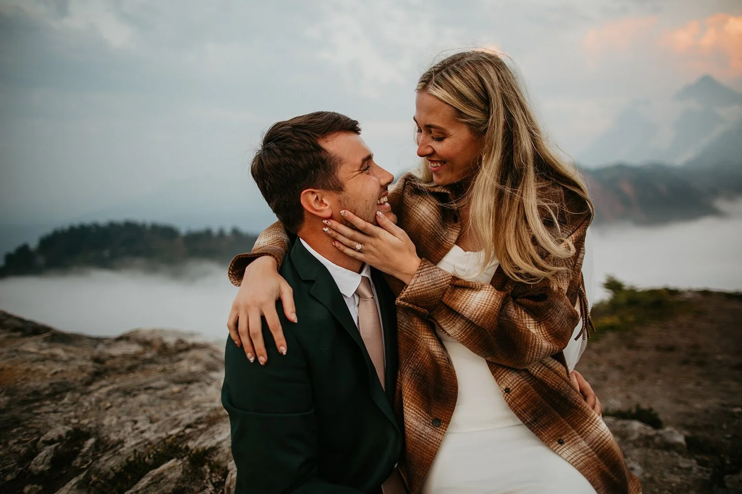 Close portrait of the couple laughing together with a foggy cloud inversion behind them