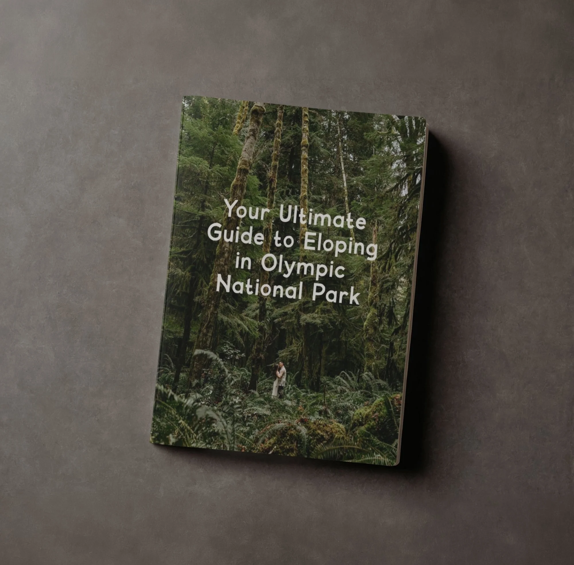 Book titled "Your Ultimate Guide to Eloping in Olympic National Park" with forest scene on the cover, featuring tall trees and greenery.