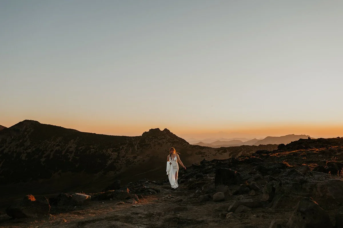 Bride walking along a rocky alpine trail at sunset during a Washington elopement