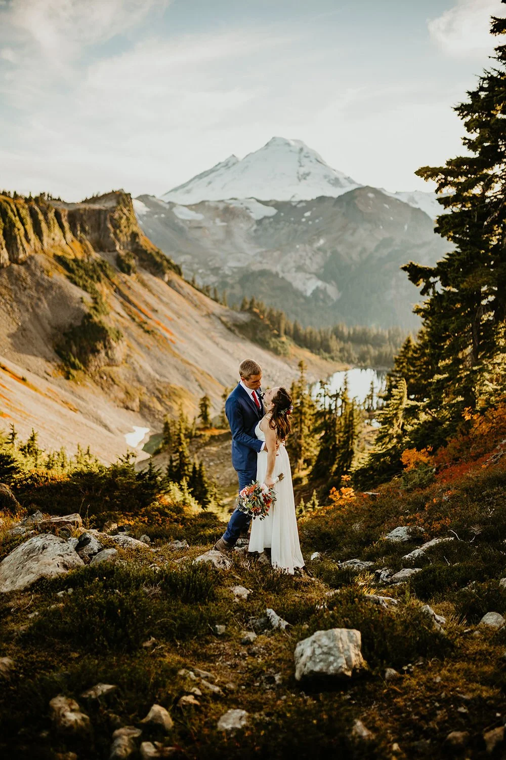 Eloping couple hiking together along a mountain trail in North Cascades National Park with expansive alpine views