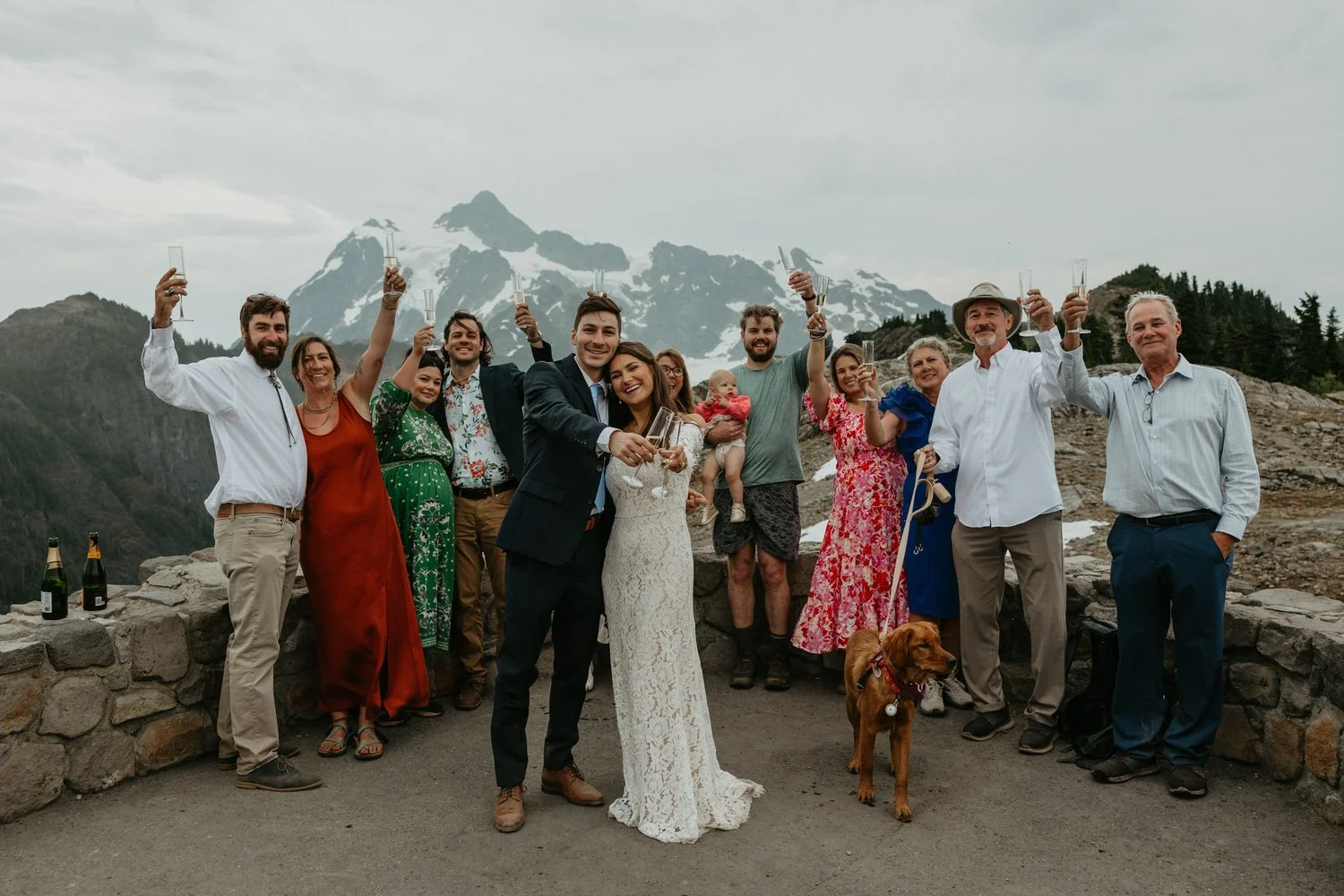 Wedding party raising champagne toasts together at Artist Point with the couple's dog included