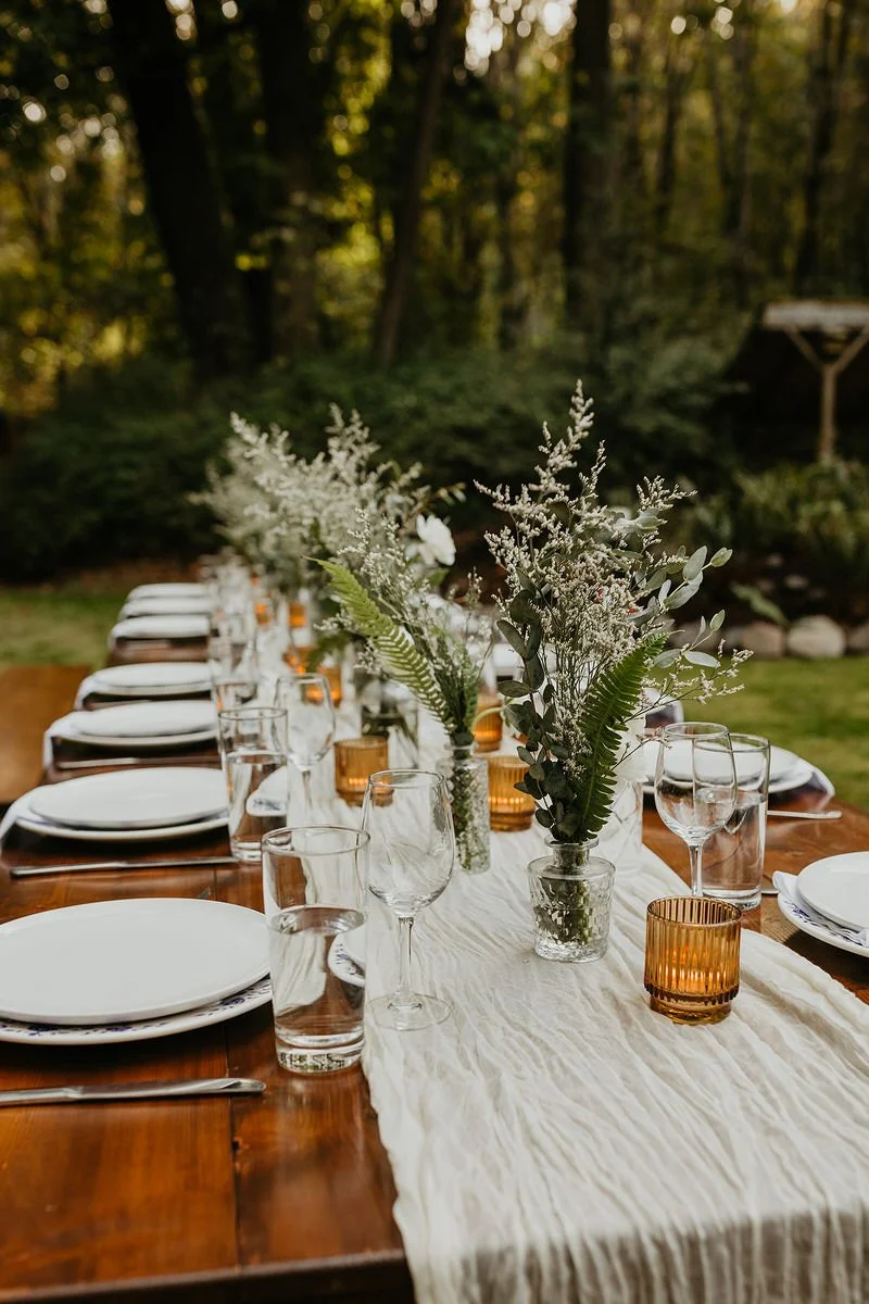 Styled reception table with floral arrangements, candles, and place settings for an intimate elopement dinner.