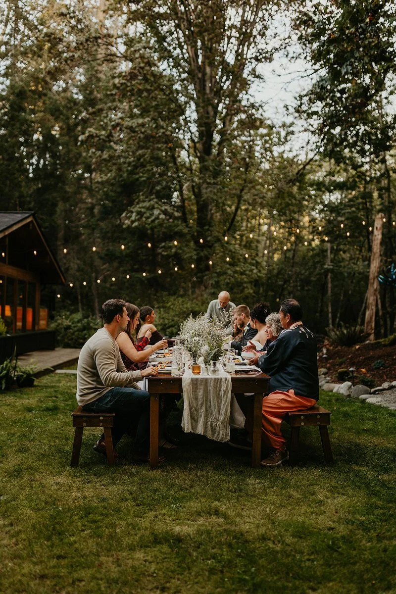 Couple and close guests sharing an intimate outdoor dinner reception after their Washington elopement.
